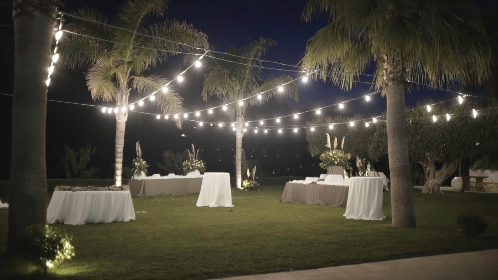 Outdoor reception set beneath warm string lights